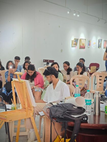 A view from the side during my indoor demo. You can see the audience engaged and watching closely as I work on the painting.