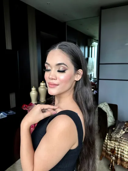 An in-between shot from a photoshoot with model Ambika. The makeup features a dramatic smokey eye, but her expression is soft and serene.