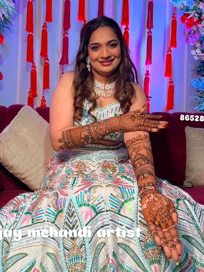 Another pose from the same bride, showing both arms covered in beautiful, intricate henna art.