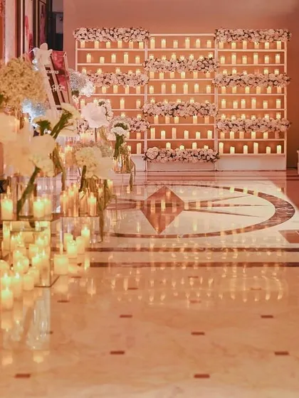 The entrance to a sangeet, lined with hundreds of candles and large white organza flowers, creating a magical, enchanted pathway for guests.