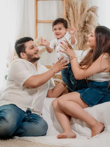 The pure joy of being together. This candid shot from a studio family session captures the happy energy and love between parents and their little boy.