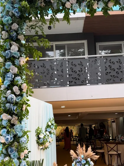 A view of the floral archway from the side, showing how it creates a beautiful frame for the event space. The mix of blue and white flowers adds a soft and calming touch.