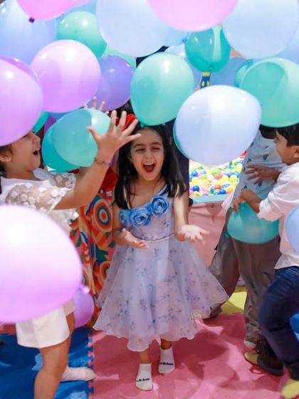 A moment of pure fun during a balloon drop. The sea of purple and blue balloons creates an exciting and immersive experience for the kids.