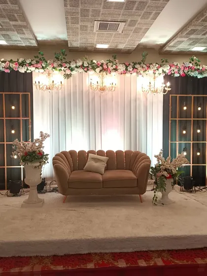 A chic and modern stage setup at Celebration banquet hall in Juinagar. The design features industrial-style light grids paired with a simple floral header, perfect for a minimalist engagement.
