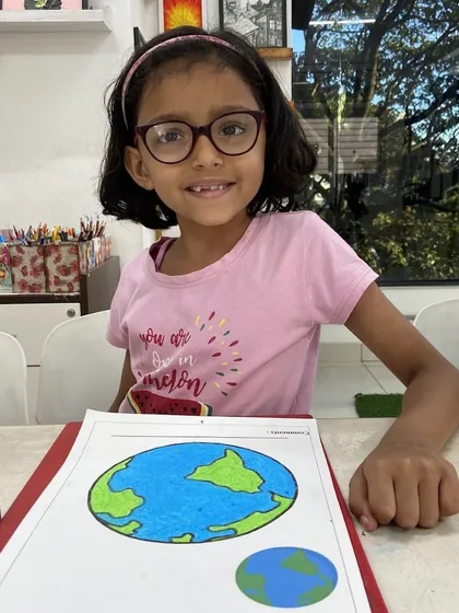 A happy student from one of our regular kids' art classes proudly displays her drawing of the Earth. Our classes focus on building fundamental skills in a relaxed, encouraging setting where every child can feel like a successful artist.