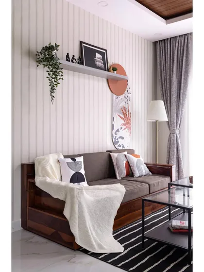 Another view of the living area with the solid wood sofa, showcasing how a simple throw blanket and curated cushions can add warmth and personality to a space.