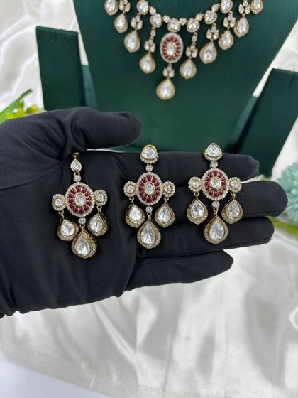 A close-up of the earrings and tikka from our Moissanite Kundan set. This highlights the fine craftsmanship and the combination of red and white stones.