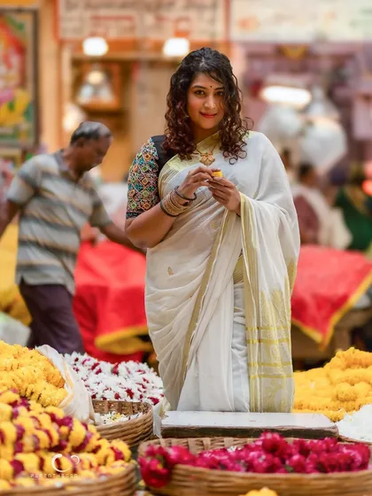 A more candid shot within the market, capturing the bustling atmosphere. Her gentle smile shows a genuine connection to the festive environment.