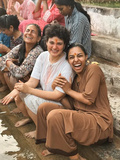Laughter is a form of yoga too. Students share a moment of pure joy by the water, a reminder that the spiritual path is also filled with lightheartedness and connection.