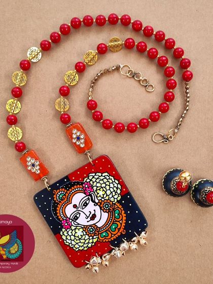A different perspective of the Lakshmi necklace set, showing the rich colours and fine details of the painting. The combination of red and blue with golden accents creates a truly divine look.