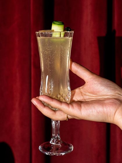We're sipping on the lighter side with this white wonder. A crisp, elegant champagne cocktail with a cucumber garnish, it's a drink whose subtle charm transports you to a new level of bliss.