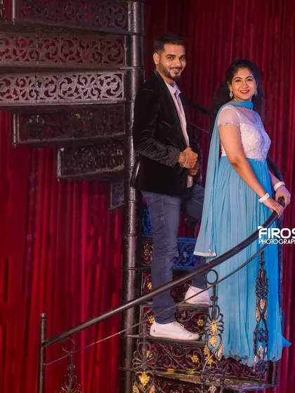 A classic pose on the spiral staircase, with the red curtain background adding a touch of old-world glamour.
