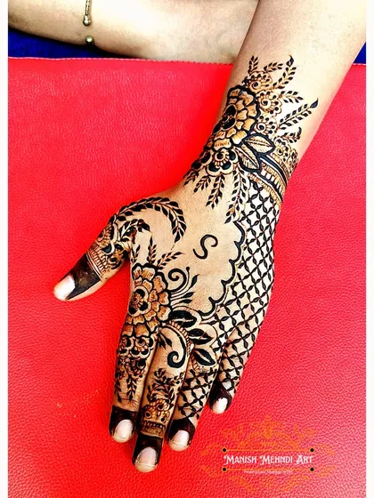 A unique back-hand design combining a net pattern (jaali) with floral elements and a custom initial 'S'. This is a great example of our personalized fusion work.