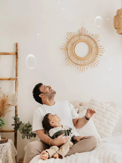 Bubbles make everything more fun! A father and son share a laugh while watching bubbles float by in this light-filled studio session.