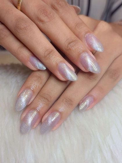 A sparkling silver cat eye effect on natural, almond-shaped nails.