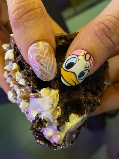 What do you love more, the chocolate waffle or the nails? This fun and quirky design features a hand-painted Daisy Duck alongside a glittery heart.