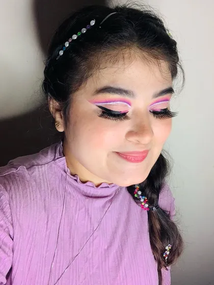 Angel vibes with this purple and white graphic liner look. The braided hair with beads completes the fantasy style.