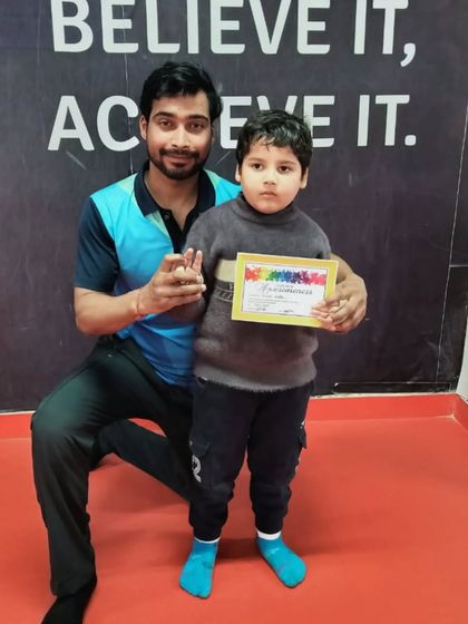 A very young student is excited to receive his certificate.