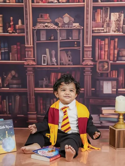 A calm and charming portrait of our little wizard, sitting amongst a pile of classic storybooks.