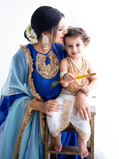 A mother's gentle kiss for her son's forehead. A sweet and traditional portrait.