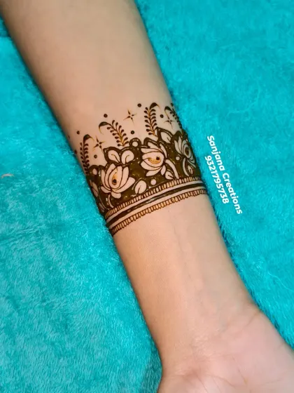 A close-up of the floral wristband from a soft bridal design. The use of negative space makes the flowers stand out beautifully.
