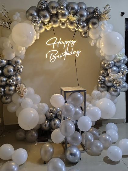 An indoor version of the silver and white balloon ring. This setup is perfect for creating a photo backdrop inside your home or at a venue.