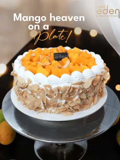 Mango heaven on a plate. This fresh cream cake is covered in toasted almonds and topped with a generous amount of fresh mango, offering a perfect balance of textures.