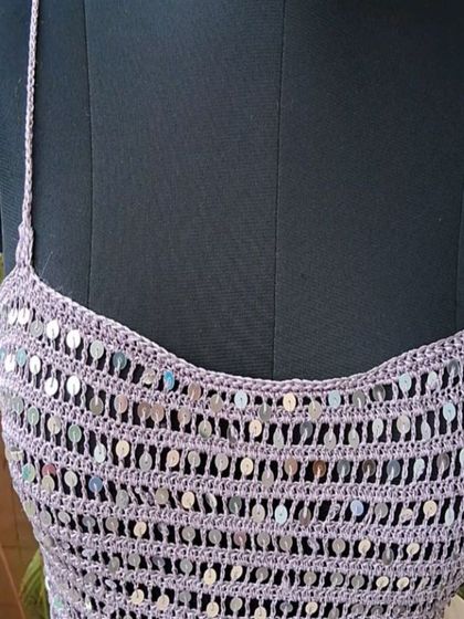 A detail shot of the neckline of the sequin dress, showcasing the delicate craftsmanship and the way the light catches the integrated sequins.