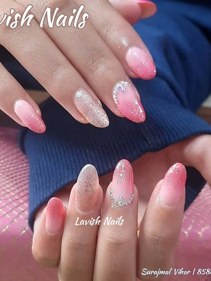A beautiful pink ombre and glitter fade on natural nails, accented with a few rhinestones.