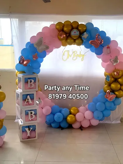 A classic gender reveal or baby shower theme with a mix of pink and blue balloons. The setup includes a circular balloon frame, "BABY" blocks, and cute baby foil balloon stands.
