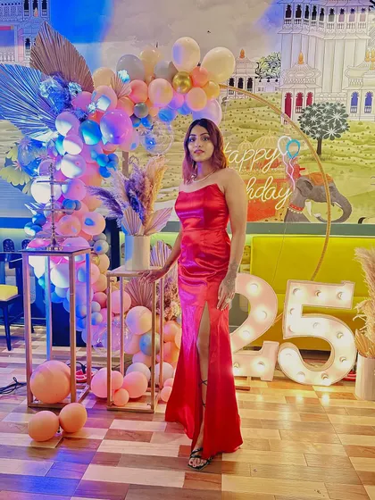 I believe in celebrating milestones with style. For my 25th birthday, I worked with a designer to create this custom red satin gown with a thigh-high slit, showing how personal style can make any occasion feel special.