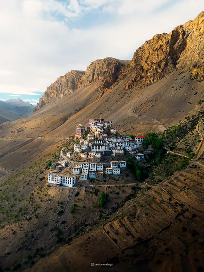 A classic view of the Key Monastery, showcasing its unique placement on the hillside. The morning light beautifully illuminates the white-washed walls of this ancient Buddhist gompa.
