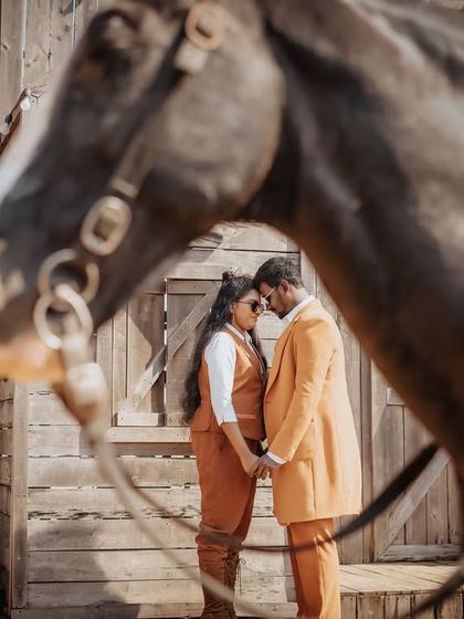 An intimate moment from a western-themed shoot, framed by a horse. This creative composition adds a unique and narrative element to the portrait.