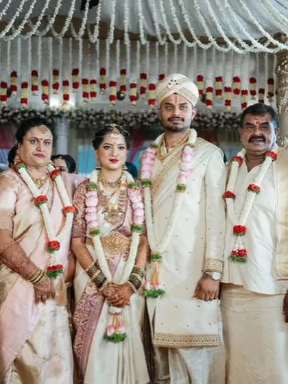 A beautiful family portrait from the wedding day. The groom's custom ivory sherwani stands out, coordinating beautifully with the attire of his bride and family members.