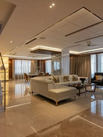 The open-plan living and dining area of the penthouse, with polished marble floors that reflect the light and create a sense of boundless space.