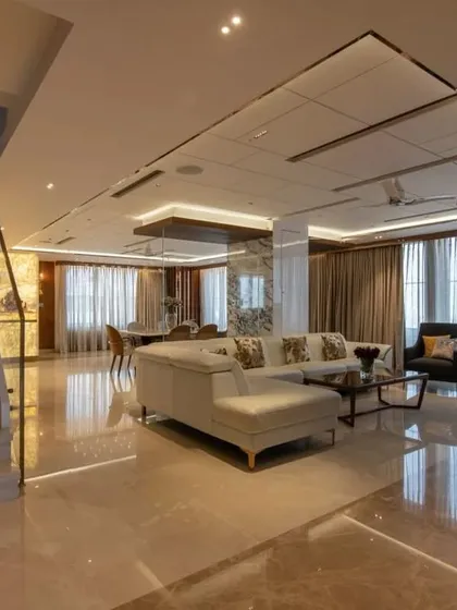 The open-plan living and dining area of the penthouse, with polished marble floors that reflect the light and create a sense of boundless space.