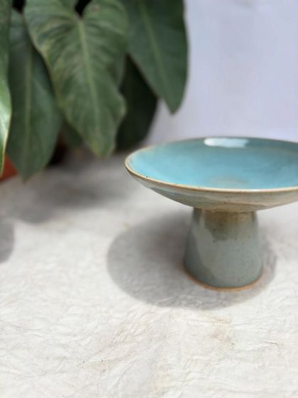 A side view of our elevated plate, showing the graceful pedestal base that gives it height and presence.
