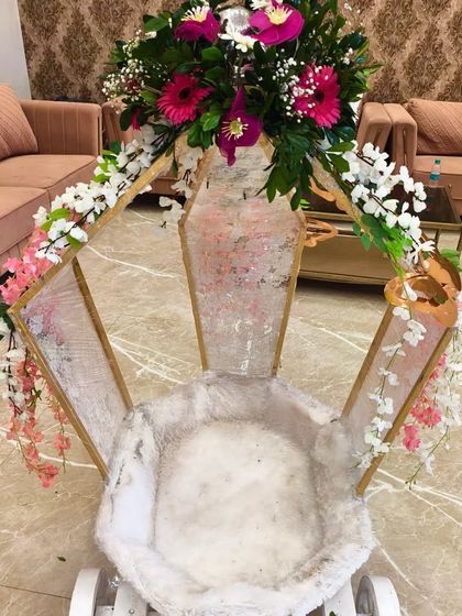 A beautifully decorated baby entry cart, adorned with fresh flowers, ready for the little princess's grand entrance at her butterfly-themed party.