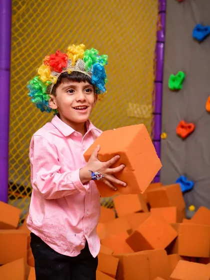 A happy clown in the foam pit, surrounded by a rainbow of colors.
