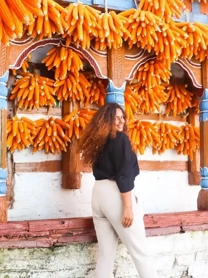 Travel style should be fun and practical. Here I am at the famous corn village in Mussoorie, wearing a simple black top and comfy white pants that let me explore freely while still looking put-together. I can help you pack a versatile travel wardrobe that works for any destination.