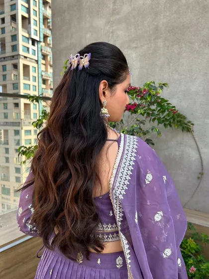 A closer look at the half-up style, accented with whimsical butterfly clips that add a touch of modern fun to the classic wavy look.