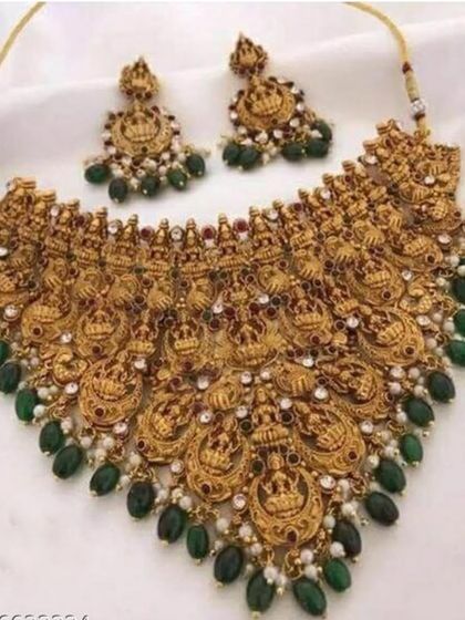 A magnificent temple jewellery choker necklace with green bead drops. The design features repeating goddess Lakshmi motifs, making it a very auspicious and traditional choice for a bride.