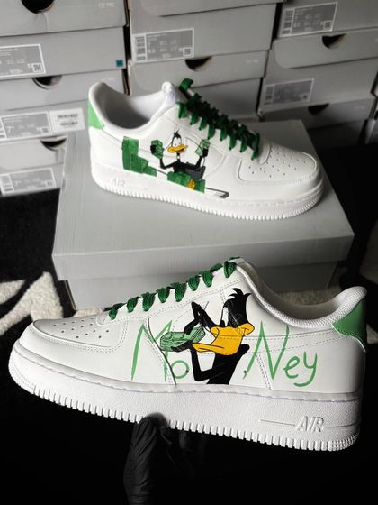 A custom Nike Air Force 1 featuring Daffy Duck with the word "Money" in a fun, cartoonish design.