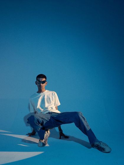 A dynamic, low-angle full-body shot. The pose is unconventional and energetic, creating a visually interesting image that stands out.