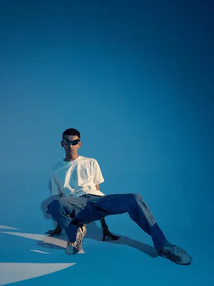 A dynamic, low-angle full-body shot. The pose is unconventional and energetic, creating a visually interesting image that stands out.