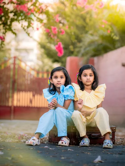 We love capturing the unique connection between siblings, like these wonderful twins. This outdoor portrait uses natural light to highlight their beautiful, coordinated outfits and shared glance.