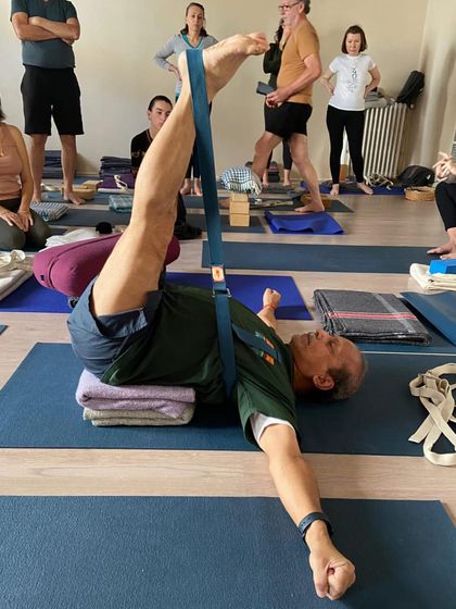 A reclining leg stretch, Supta Padangusthasana, being demonstrated at the inaugural classes of Yogashala Arles in France.