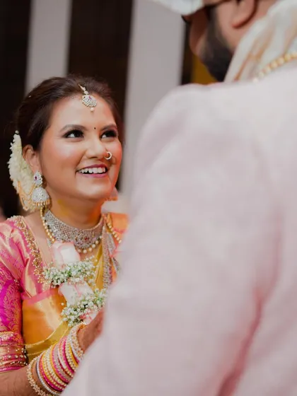 A beautiful, candid moment between the bride and groom, capturing her joyful expression and glowing makeup.