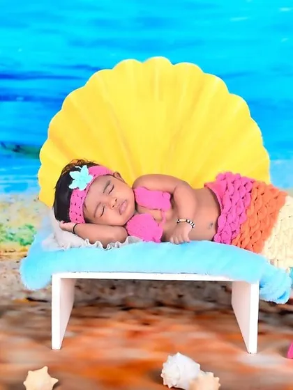 A sleepy newborn transformed into a beautiful mermaid, complete with a colorful tail and a seashell backdrop.