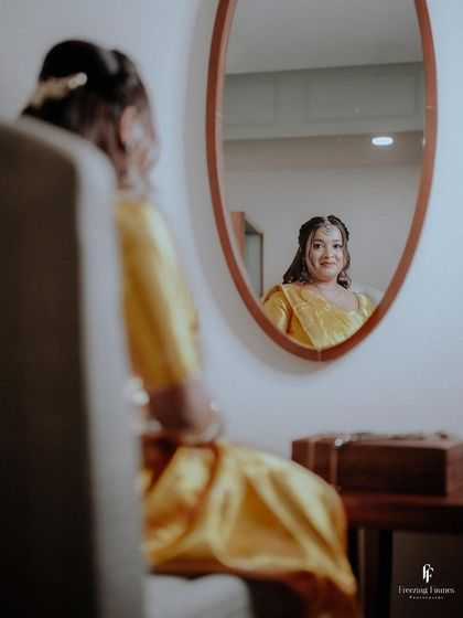 A bride looking at her reflection in the mirror, a quiet moment of contemplation during her engagement day.